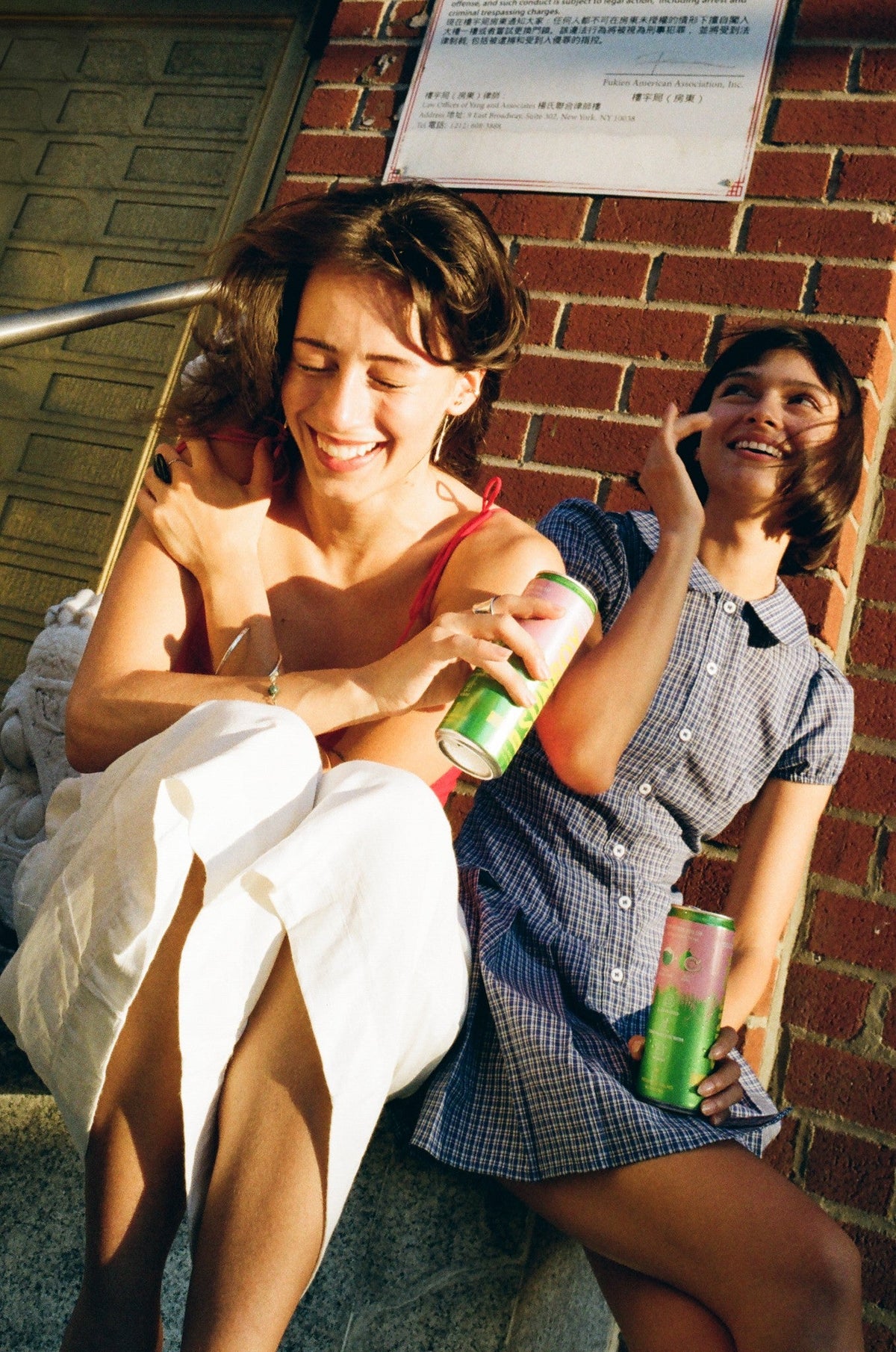 Two friends laughing on a stoop with SUNBOY